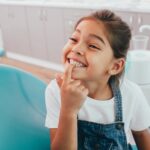smiling child in dental chair to prevent pediatric dental issues