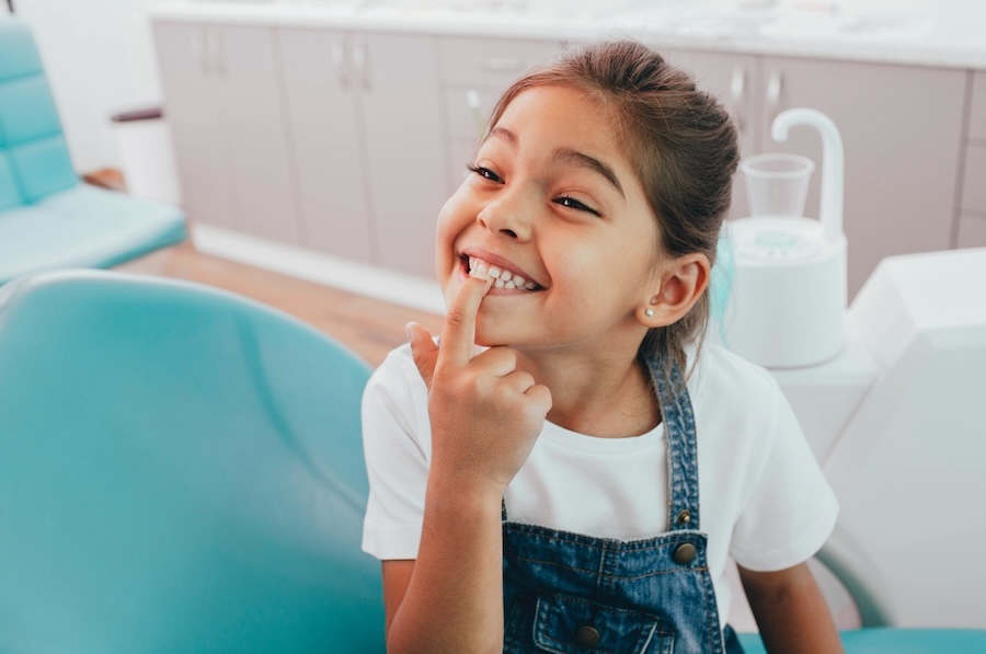smiling child in dental chair to prevent pediatric dental issues